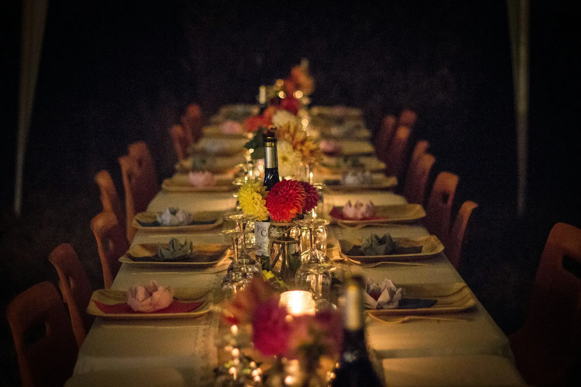 Mesa larga de banquete servida a la luz de las velas